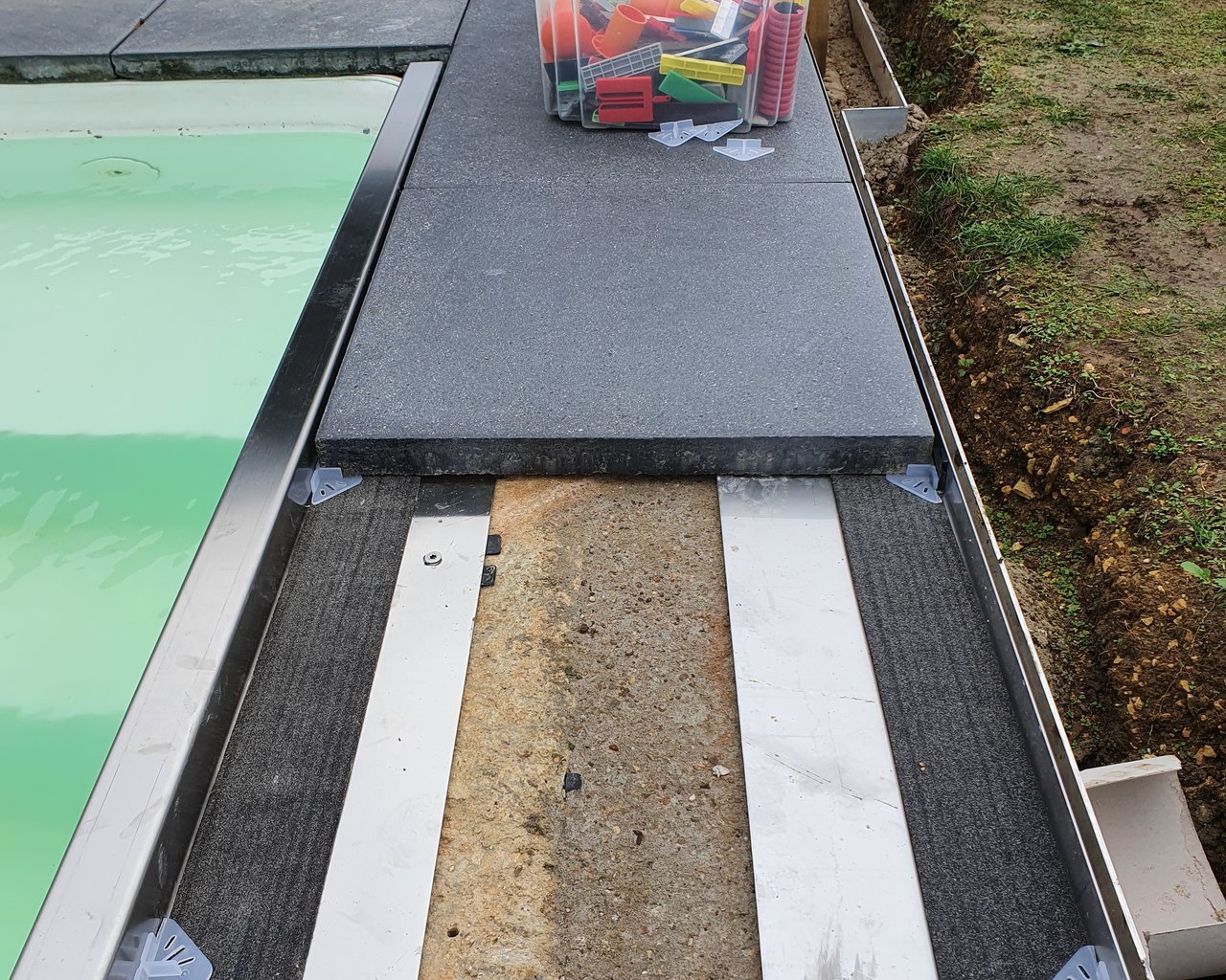 Aménagement d'une bordure de piscine - pose de profilé inox - mise en place de dalles - étape 2